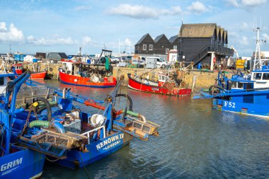 Kırmızı ve mavi balıkçı tekneleri Whitstable Limanı 'na yanaştı, Kent.