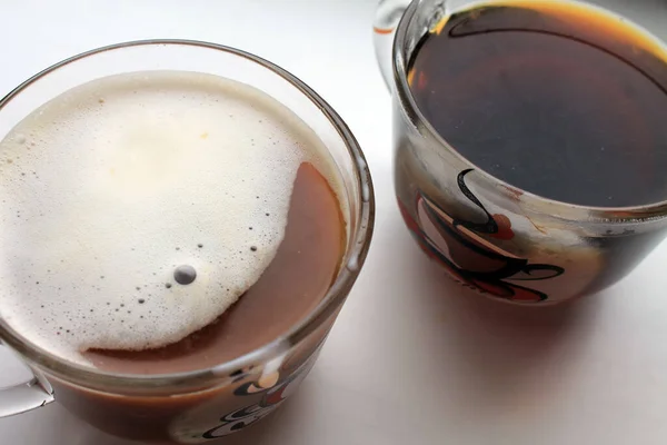Bir bardakla iki bardak. Koyu kahve ve kremalı kahve..