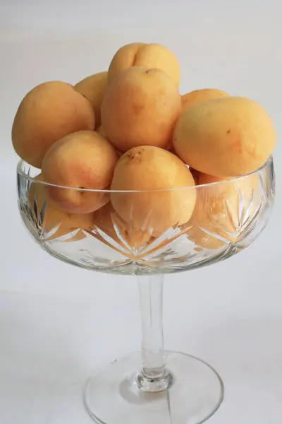 Şeffaf cam vazoda kayısılar. Meyveler.