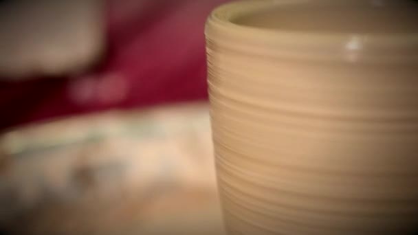 Rå lerkrukor burkarna stå och vänder potters wheel i potters verkstaden nära — Stockvideo