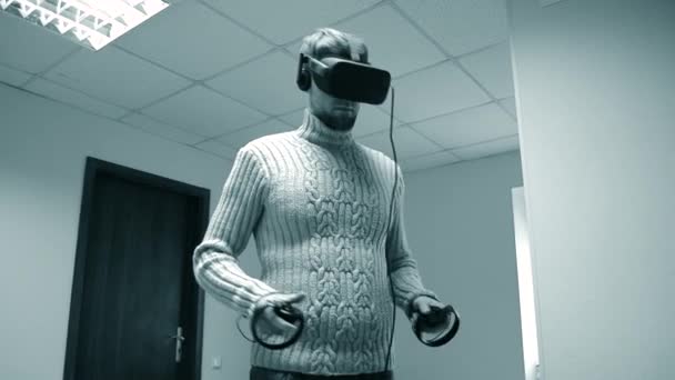 Ο άνθρωπος σε ένα σετ κεφαλής εικονικής πραγματικότητας είναι ένα παιχνίδι στο γραφείο. — Αρχείο Βίντεο
