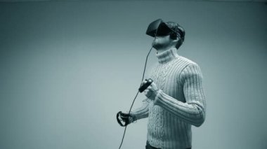 Bir sanal gerçeklik kask içinde adam. Ofiste bej renkli bir arka plan üzerinde genç erkek Avrupa beyaz ellerinde bir joystick ile bir sanal gerçeklik kask içinde bir oyun oynarken kapatmak izole