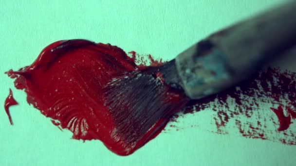 Drawing with a paintbrush on white paper with red oil paint close-up. — Stock Video