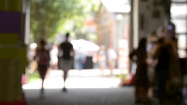 Fondo borroso. La gente sale a la luz por la puerta abierta . — Vídeos de Stock