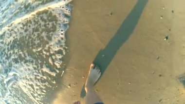 Ağır çekim. Kumlu plaj boyunca kızdır ve dalgalar rulo ayağına sabah akşam parlak güneşli bir günde. Geri kalan sakin yaz rekreasyon tatil tatil kavramı. Üstten görünüm