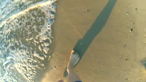 慢动作 这个女孩正在沙滩上散步 在清晨的阳光明媚的日子里 她的脚上波浪翻滚着 概念休息放松暑假休闲度假 顶部视图 — 图库视频影像