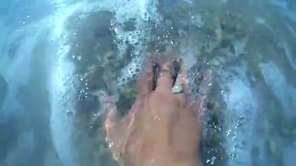 Holky ruka leží na mušle, kterou písečná pláž a moře vlny je postupné uzavření — Stock video