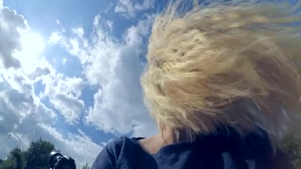 Bir sarışın kız bir eğik kafa ile oturur — Stok video