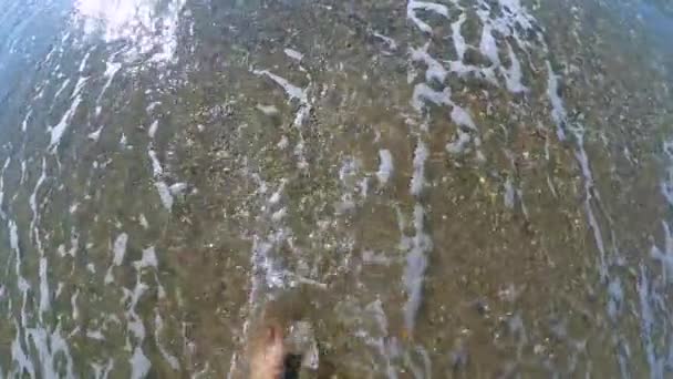 Slow-motion. Het meisje is wandelingen langs het zandstrand en golven rollen — Stockvideo