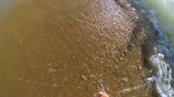 En cámara lenta. La chica es paseos a lo largo de la playa de arena y olas rollo — Vídeo de stock