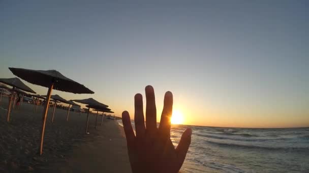 Mano dedos sol puesta del sol playa mar océano — Vídeos de Stock