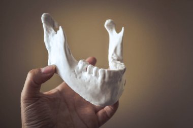Bir kız avuç içindeki 3D yazıcıda çene izi tutuyor.