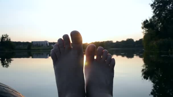 POV La silhouette nera di piedi lo muove in aria, attraverso raggi delle dita — Video Stock