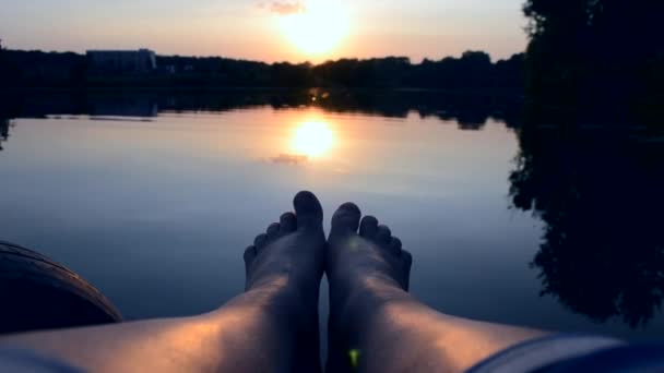 Los pies se encuentran en el muelle cerca del estanque del lago — Vídeo de stock