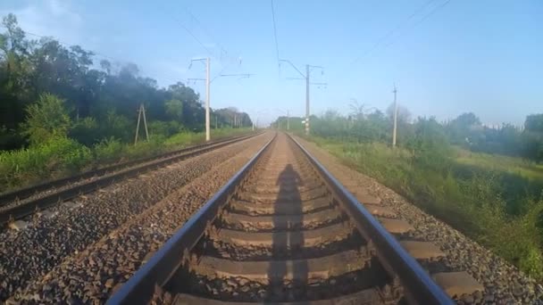 Schatten eines Mannes, der auf einer Eisenbahn läuft. — Stockvideo