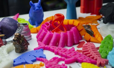 Many bright multi-colored objects printed on 3d printer lie on flat surface clipart