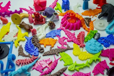 3d yazıcıya basılmış pek çok parlak renkli nesne düz yüzeyde yatıyor