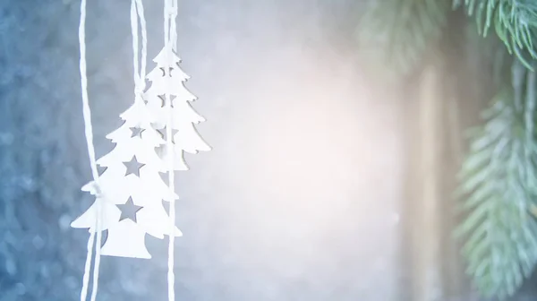 Zwei kleine weiße Weihnachtsbäume hängen auf dem Hintergrund einer grauen Wand — Stockfoto