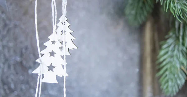 Zwei kleine weiße Weihnachtsbäume hängen auf dem Hintergrund einer grauen Wand — Stockfoto