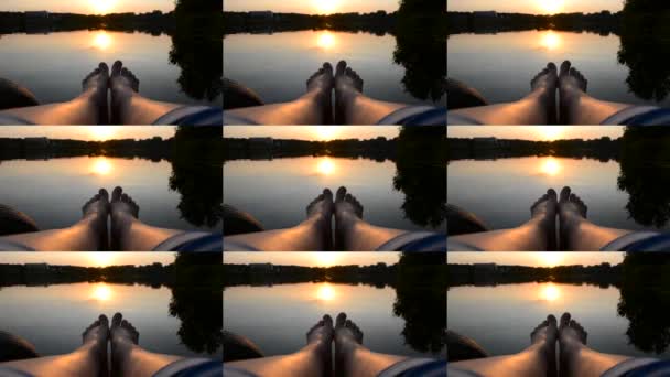 Pés pernas jazem no cais perto lago lagoa ao pôr do sol amanhecer nascer do sol close-up . — Vídeo de Stock