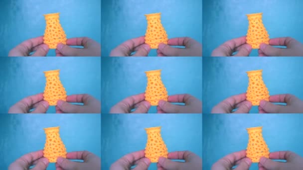 La persona sostiene sus manos y ve el objeto amarillo creado en la impresora 3D. — Vídeo de stock