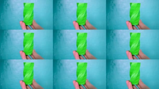 La persona tiene sulle mani e visualizza l'oggetto verde creato sulla stampante 3d. — Video Stock