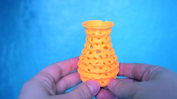 De persoon houdt zijn handen vast en bekijkt geel object gemaakt op 3d printer. — Stockvideo