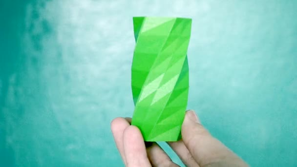 A pessoa segura em suas mãos e ver objeto verde criado na impressora 3d. — Vídeo de Stock