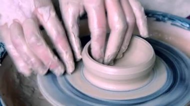 Kadın kız ellerini duvara sürahi dub, kil daire dışında sculpts.