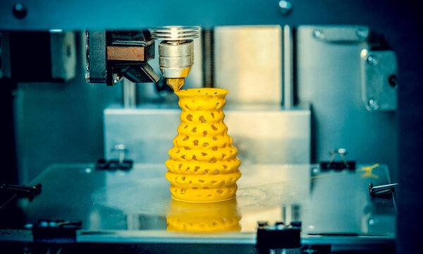 3d printer printing objects yellow form closeup.