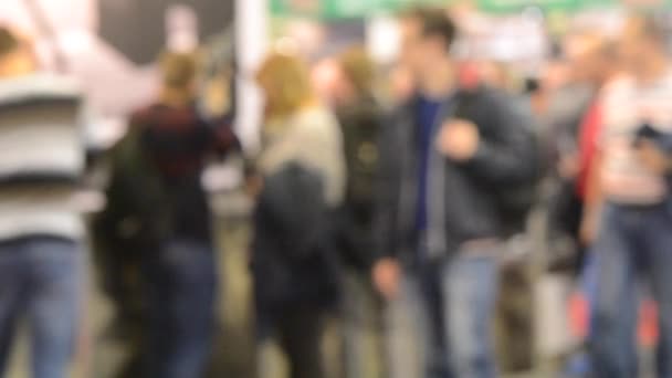 Mucha gente camina dentro de la tienda de exposiciones del centro comercial . — Vídeos de Stock