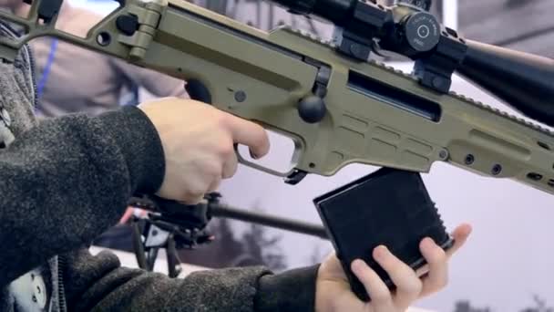 Weapon optics sight of sniper rifle with man close-up in store or shop. — Stock Video