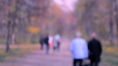 Birçok kişi parkta yürümek. Arka plan bulanık