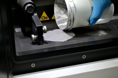 Adam metal tozu bir lazer sinterleme makine odasına dökülen.