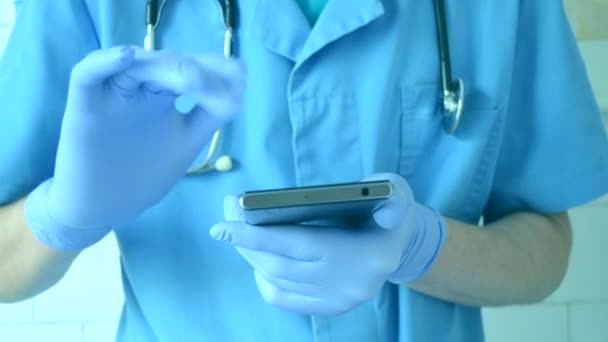 Doctor en guantes azules y azul corre en un teléfono móvil — Vídeo de stock