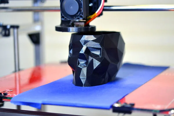 Stampante 3D che stampa un modello sotto forma di primo piano con teschio nero — Foto Stock