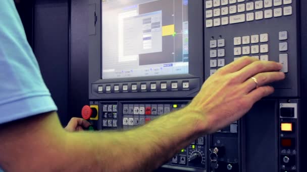 El hombre que trabaja en el panel de control trabaja con una máquina industrial en la fábrica — Vídeo de stock