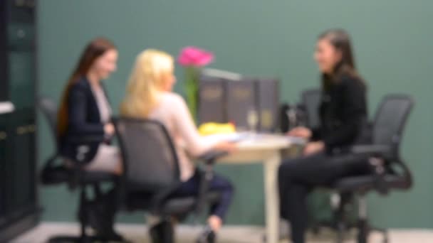 Onscherpe achtergrond zakenvrouw zitten aan de tafel en bespreken van zaken — Stockvideo