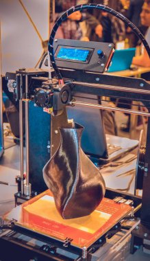 3D yazıcı siyah vazo gibi yakın plan bir model yazdırıyor.