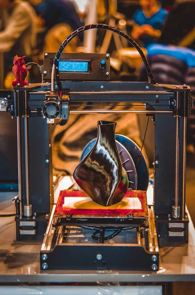 3D yazıcı siyah vazo gibi yakın plan bir model yazdırıyor.