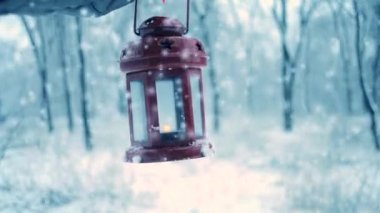 Kırmızı eldiven kırmızı mum fener kış ormandaki holding.