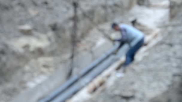 Los trabajadores ponen tuberías con una grúa de construcción — Vídeos de Stock