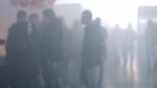 Veel mensen lopen in een rook gevulde ruimte — Stockvideo