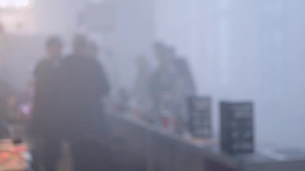 Mucha gente camina en una habitación llena de humo — Vídeo de stock