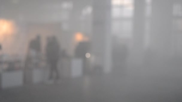 Many people walk in a smoke filled room — Stock Video