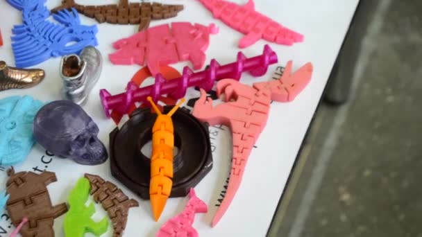 Objetos coloridos brilhantes impressos em uma impressora 3D em um close-up de mesa . — Vídeo de Stock