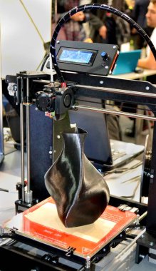 3D yazıcı siyah vazo gibi yakın plan bir model yazdırıyor.