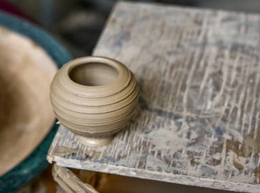 Küçük kil vazo bir ahşap tahta üzerinde duruyor