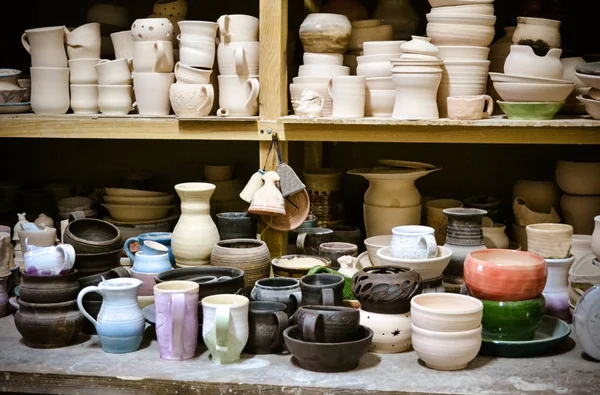 Много различных керамики, стоящих на полках в мастерской — стоковое фото