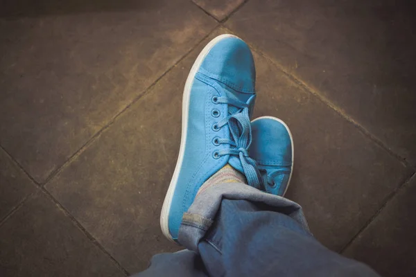 Feet jeans sneakers floor. Dark filter Royalty Free Stock Photos